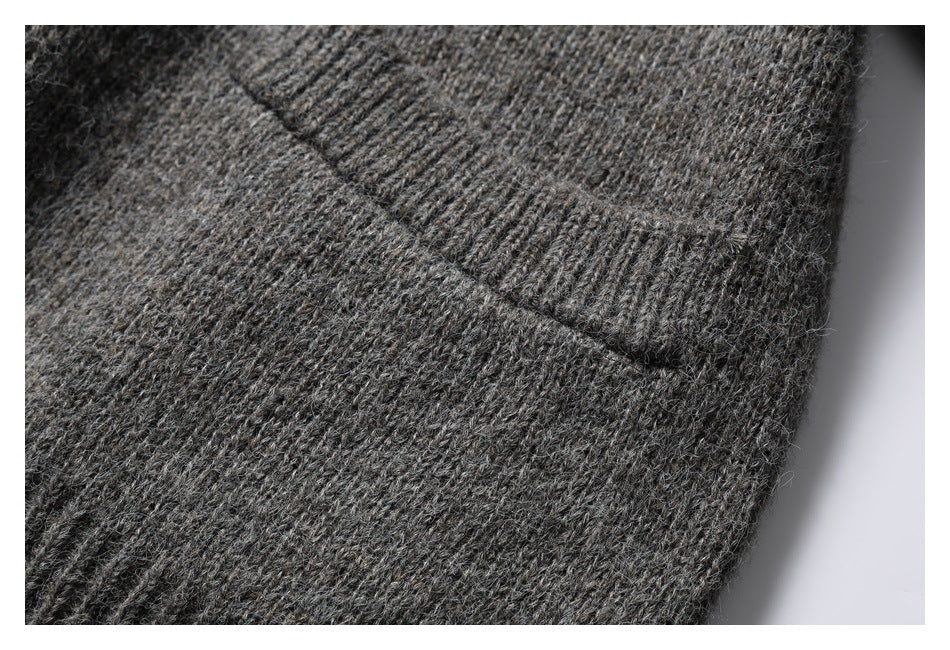 Close-up of a charcoal gray knit cardigan pocket edge and textured knit.
