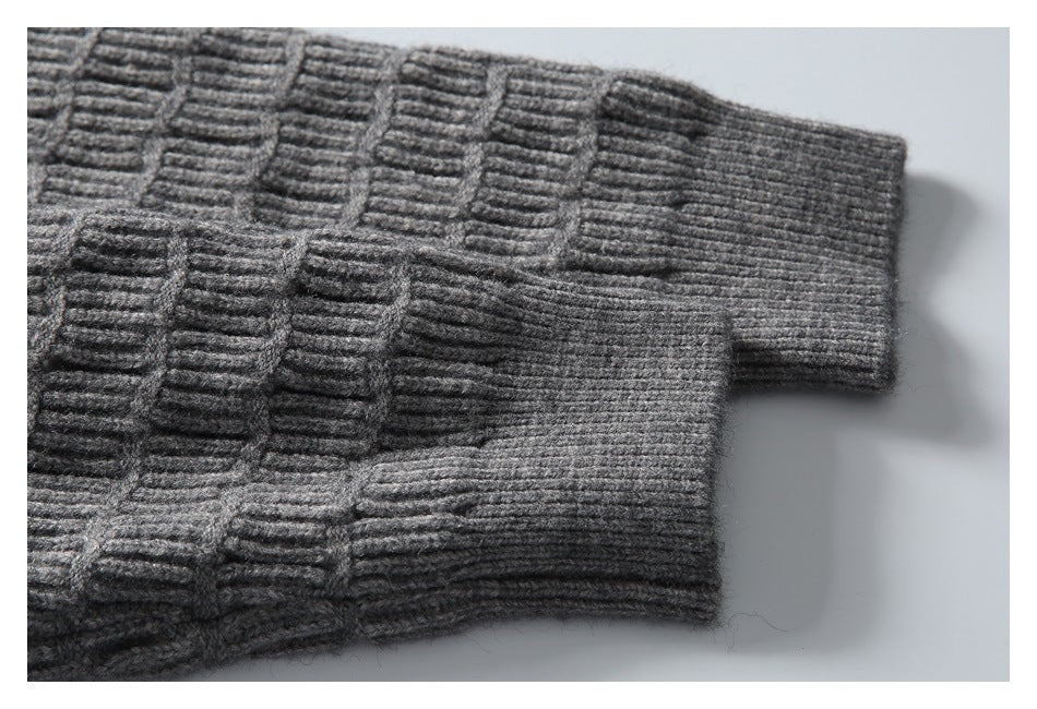 Close-up of the gray sweater's sleeve showing the raised block-knit pattern and ribbed cuff.