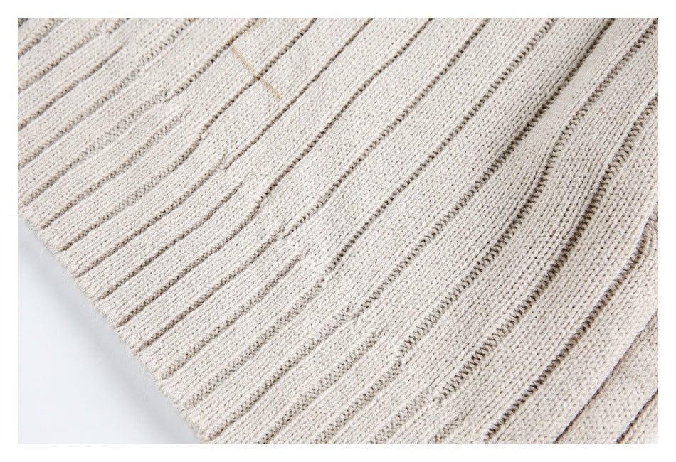 Close-up showing the cream garment's alternating raised and narrow rib-knit stripes.