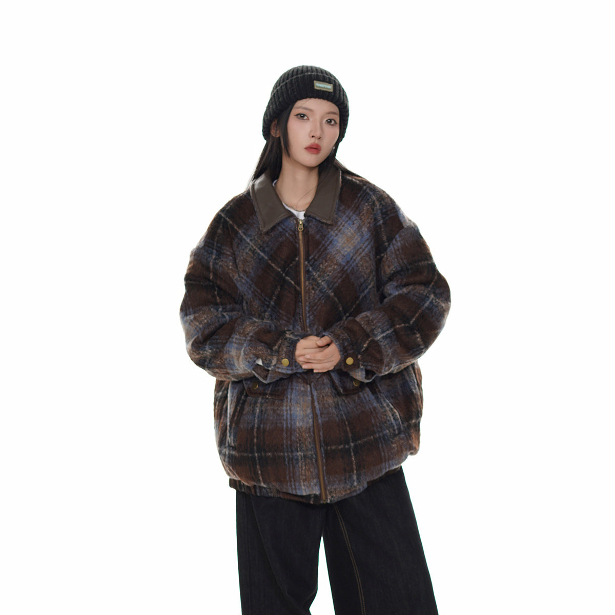 Model wearing a brown and blue plaid jacket zipped at the front, with a dark collar and buttoned cuffs.