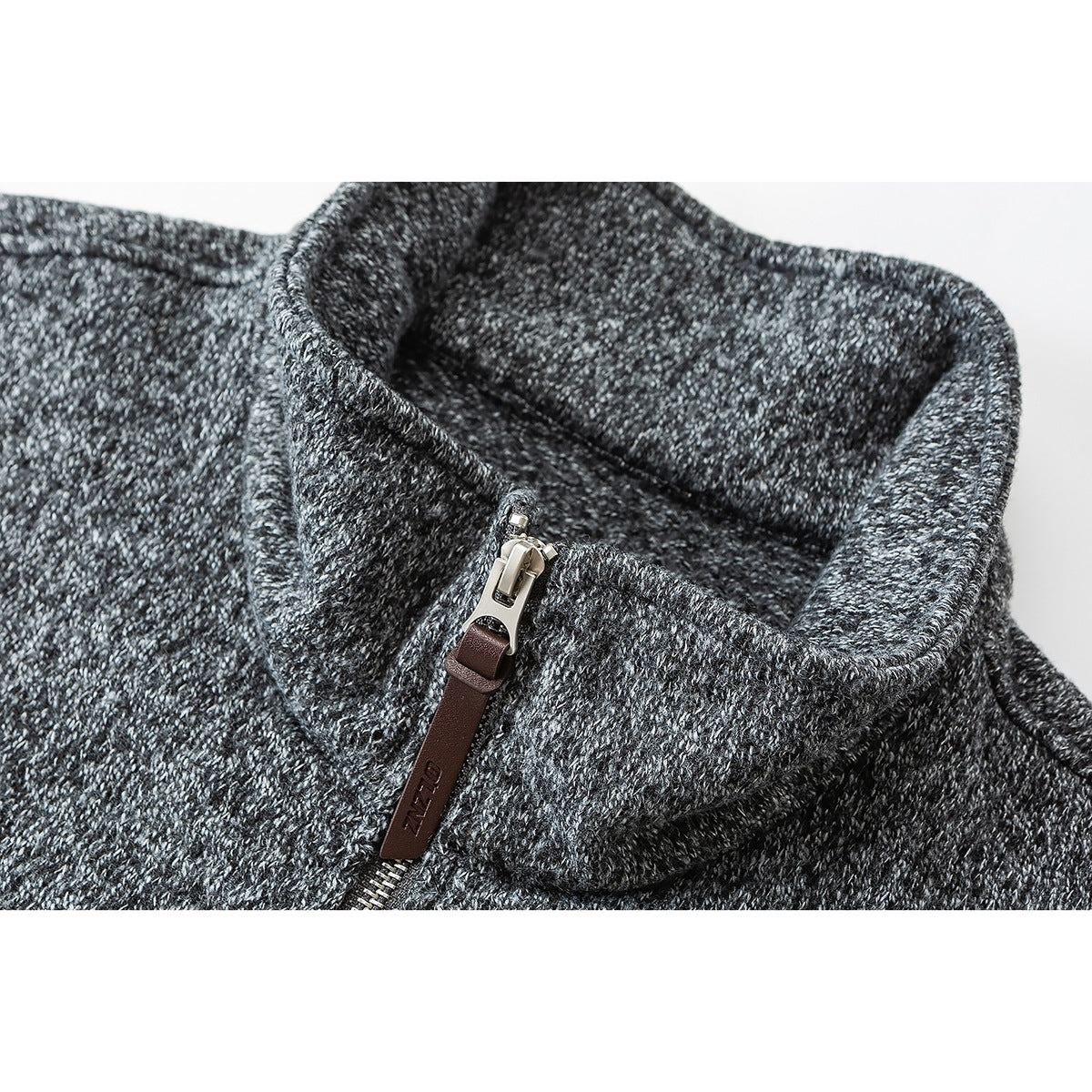 Close-up of a charcoal marled pullover's raised collar and metal zipper with a brown pull tab.