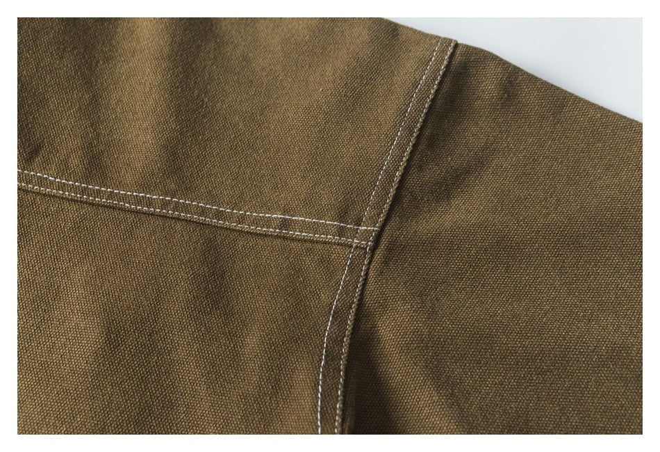 Close-up of a brown jacket shoulder seam with contrasting double stitching.
