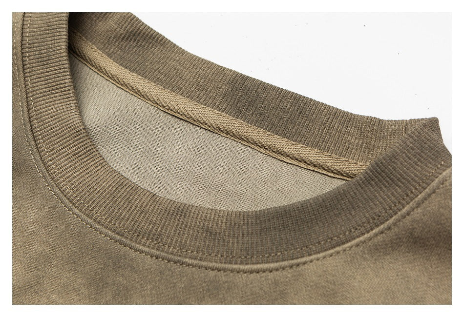 Close-up of the ribbed crewneck collar and inside neckline of a tan-brown sweatshirt.