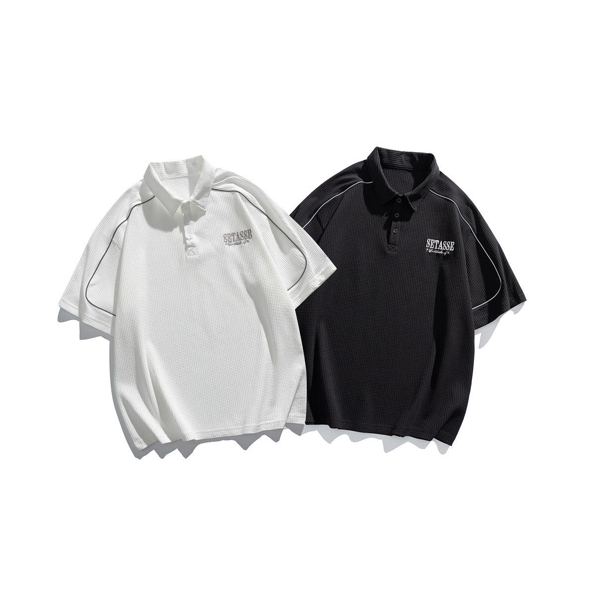 White and black short-sleeve polo shirts displayed together, with collars, chest embroidery, and contrast piping.