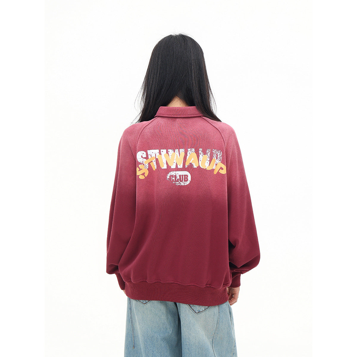 Back view of a model wearing a rose-red pullover with a large white and yellow graphic across the back.