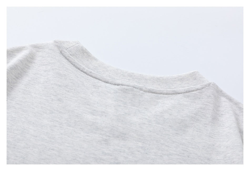 Close-up of the crew neckline and shoulder area of a light gray heather garment.