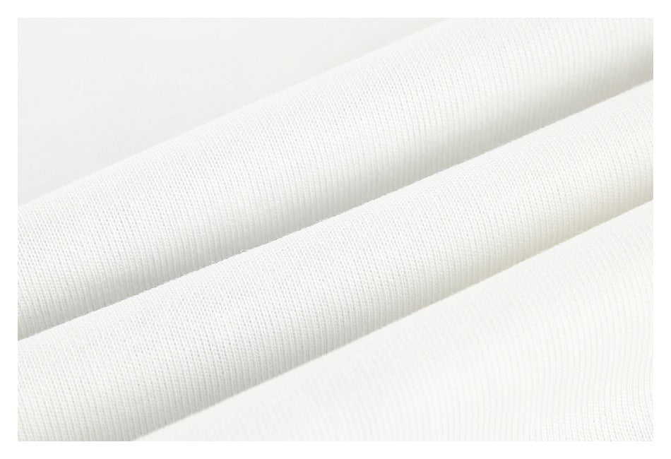 Close-up of white knit fabric folded into soft ridges, showing its fine ribbed texture.