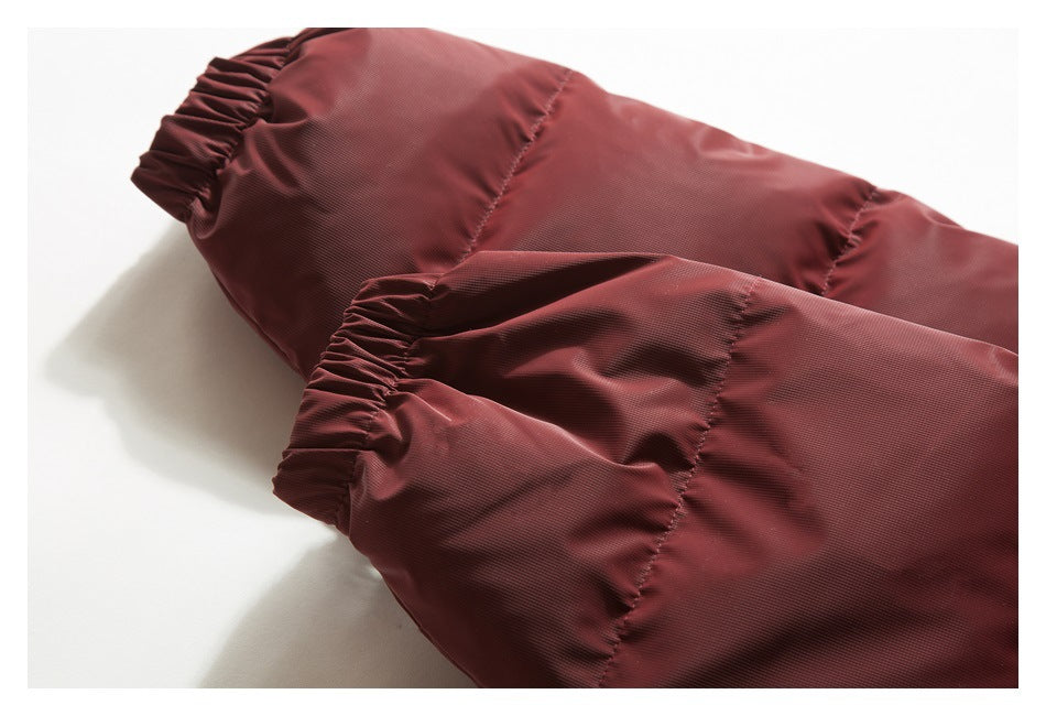 Close-up of two gathered elastic cuffs on a burgundy jacket.