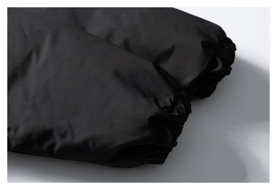 Close-up of black garment fabric ending in gathered elastic cuffs.