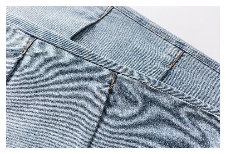 Close-up of light blue denim panels and contrasting seam stitching.