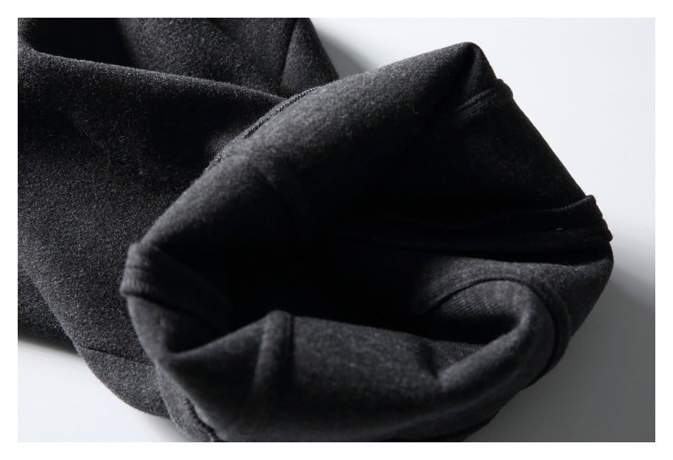 Close-up of a folded opening in the charcoal gray trousers, showing the inner fabric and stitched edge.