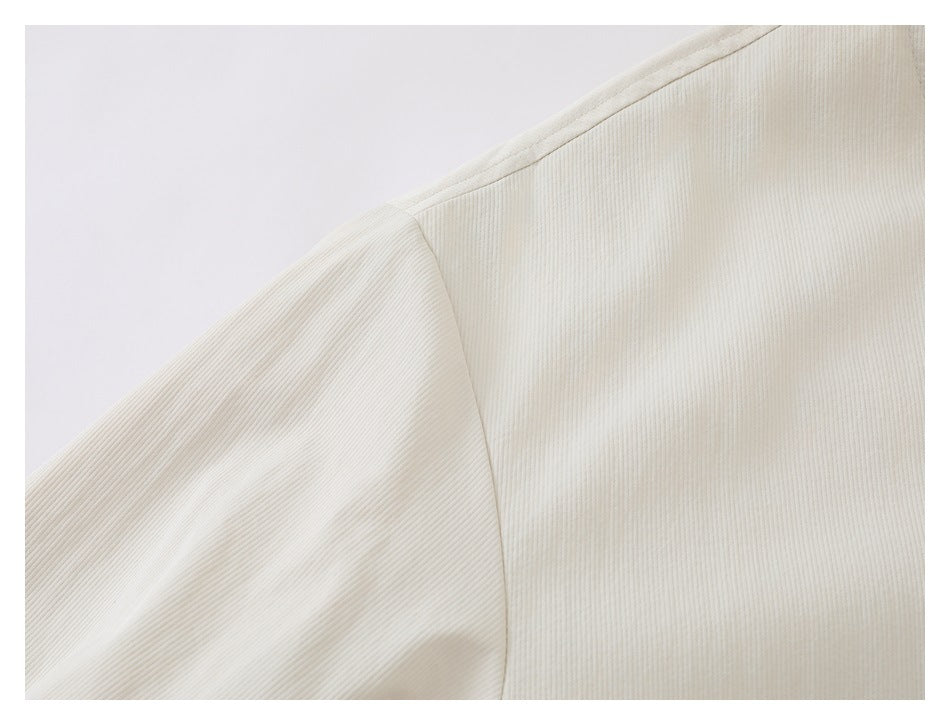 Close-up showing the ivory garment's shoulder seam and sleeve join.