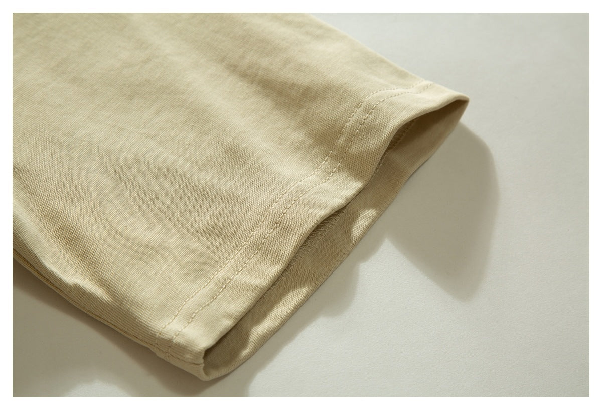 Close-up of a light beige garment sleeve opening and stitched edge.
