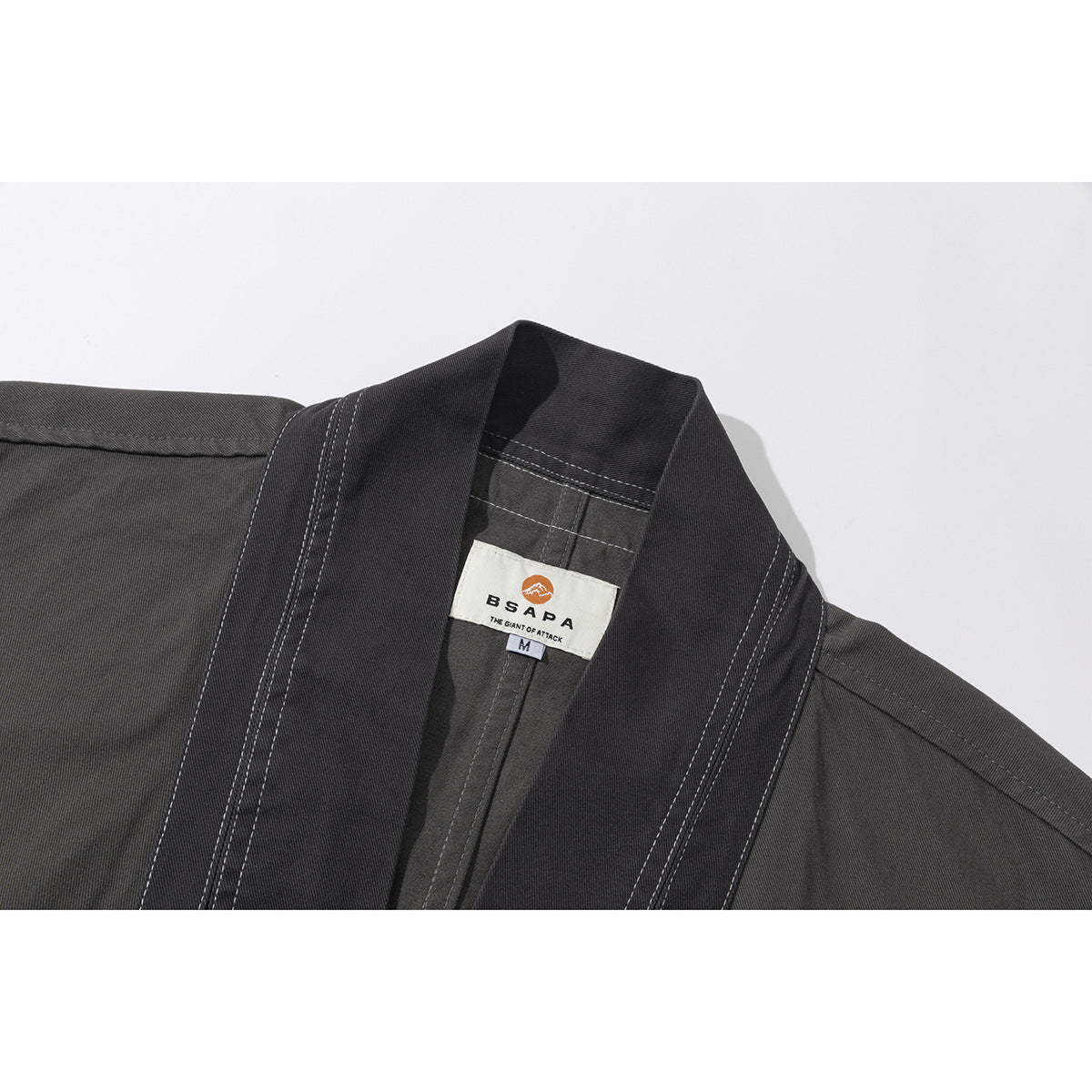 Close-up of a charcoal jacket collar with contrasting stitching and a sewn brand and size label.