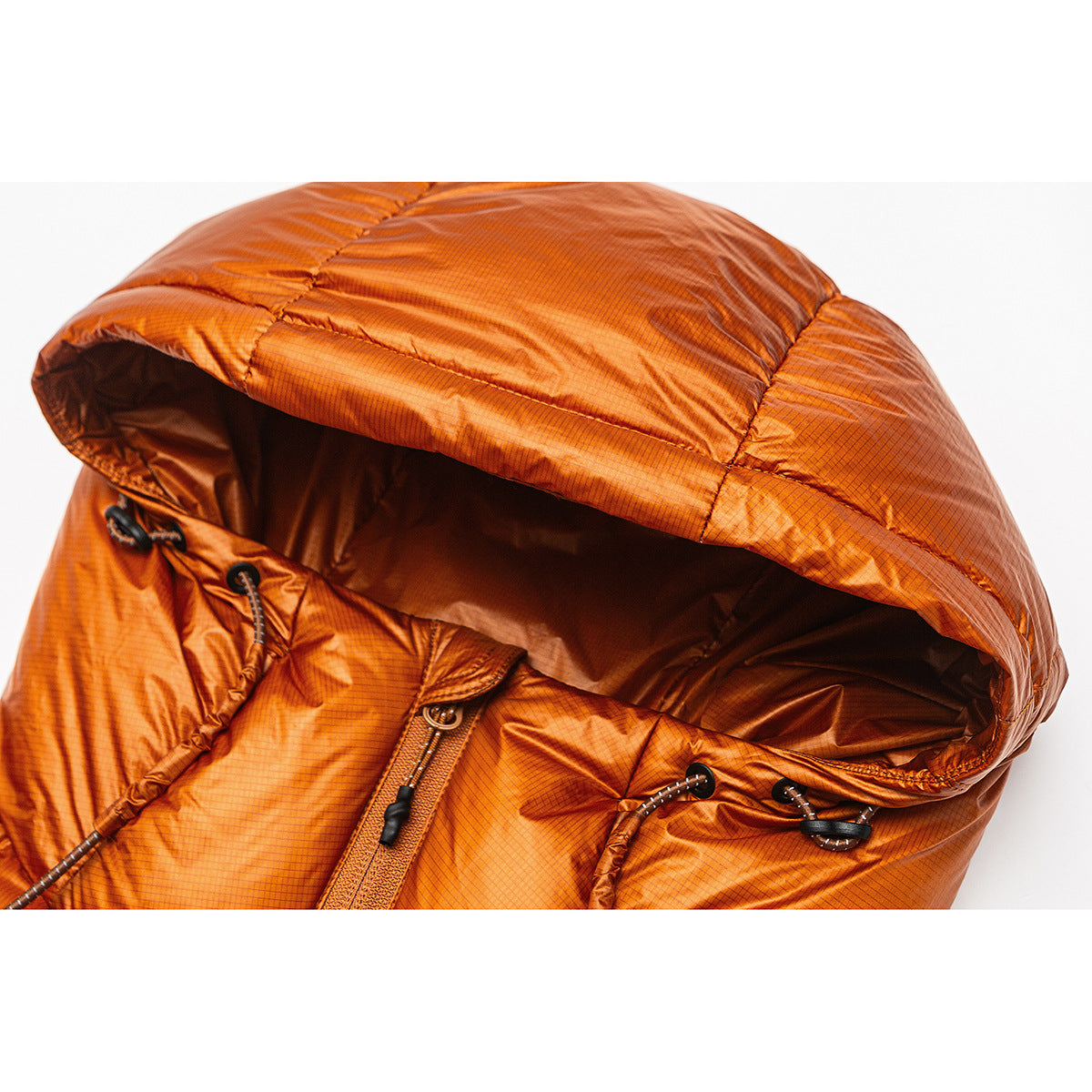 Close-up of an orange quilted jacket hood with drawcords and toggles.