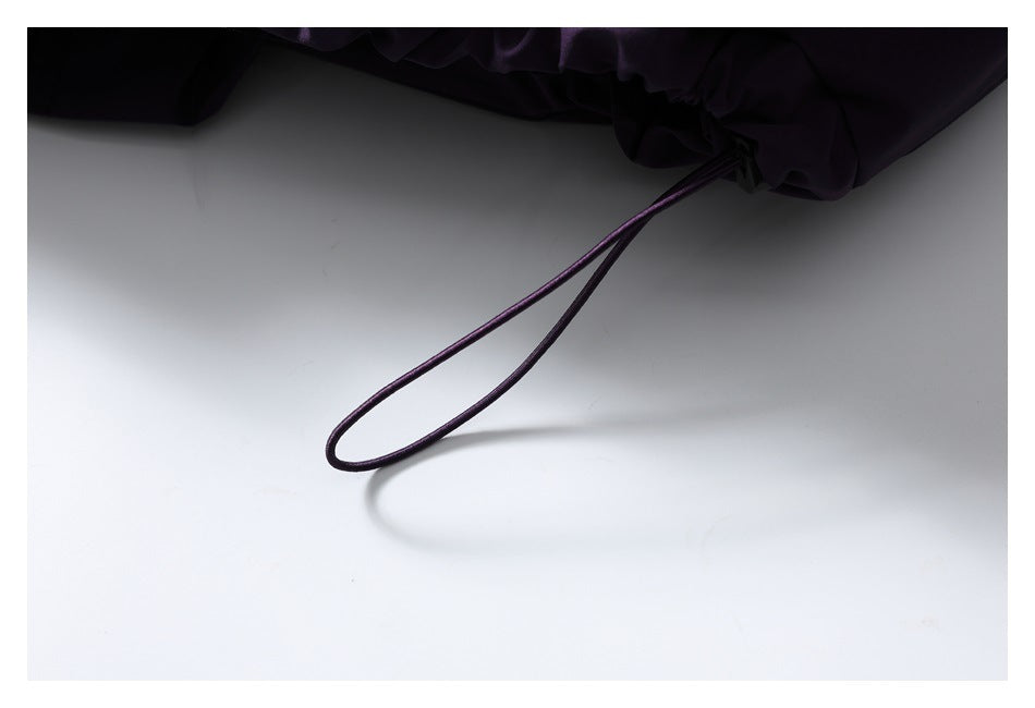 Close-up of a looped drawcord at the hem of the deep purple jacket.