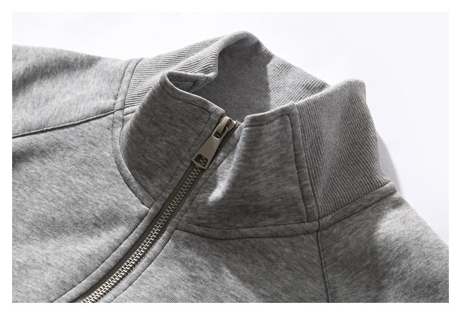 Close-up of a gray jacket's ribbed stand collar and metal front zipper.