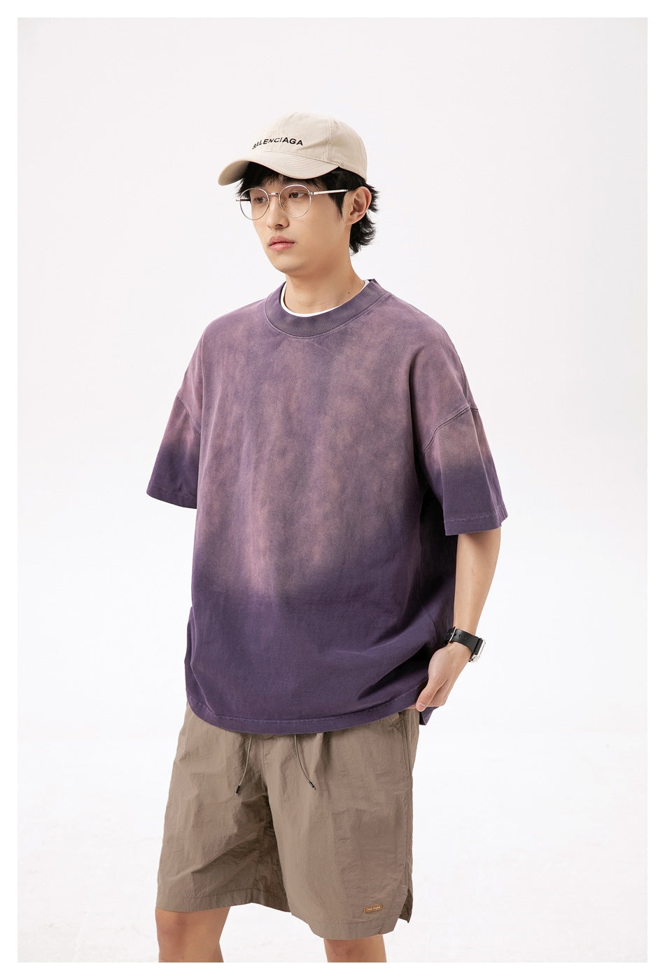 Front view of a model wearing an oversized mottled purple short-sleeve T-shirt with a crew neck.
