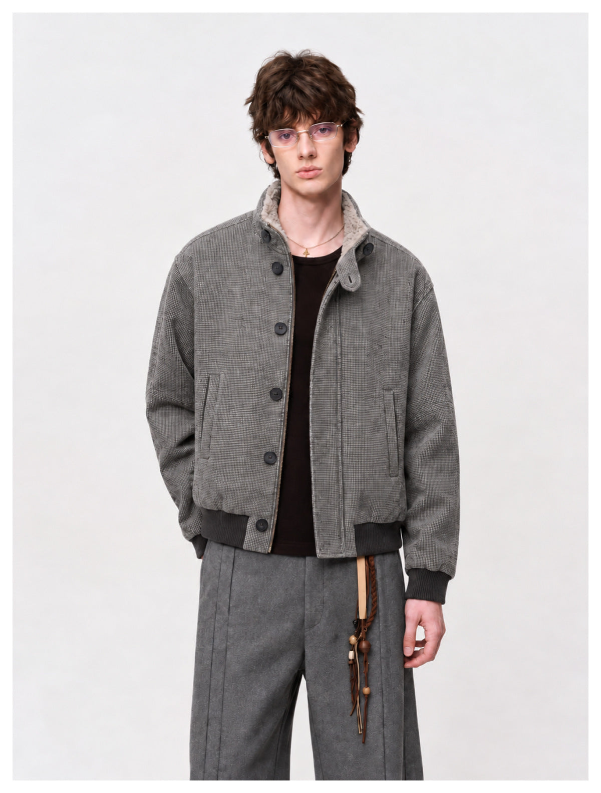 Model wearing a gray patterned bomber jacket with a button front, two pockets, ribbed trim, and a fleece-lined collar.