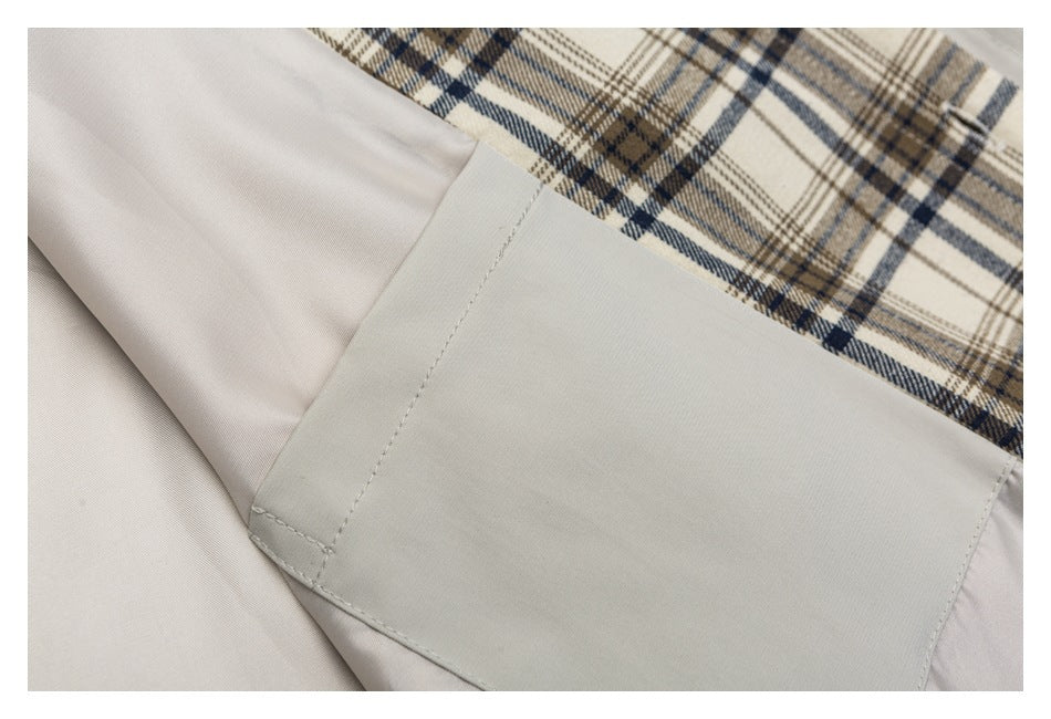Close-up of a light gray garment panel beside beige, brown, and navy plaid fabric.