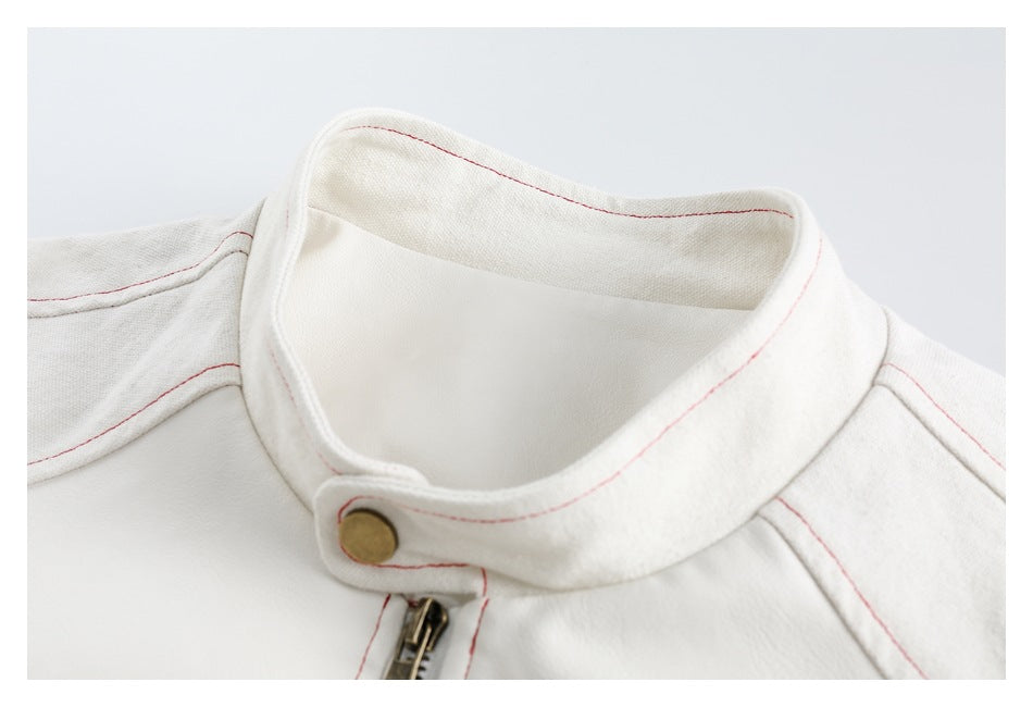 Close-up of the off-white jacket's stand collar, brass snap, zipper, and fine red stitching.