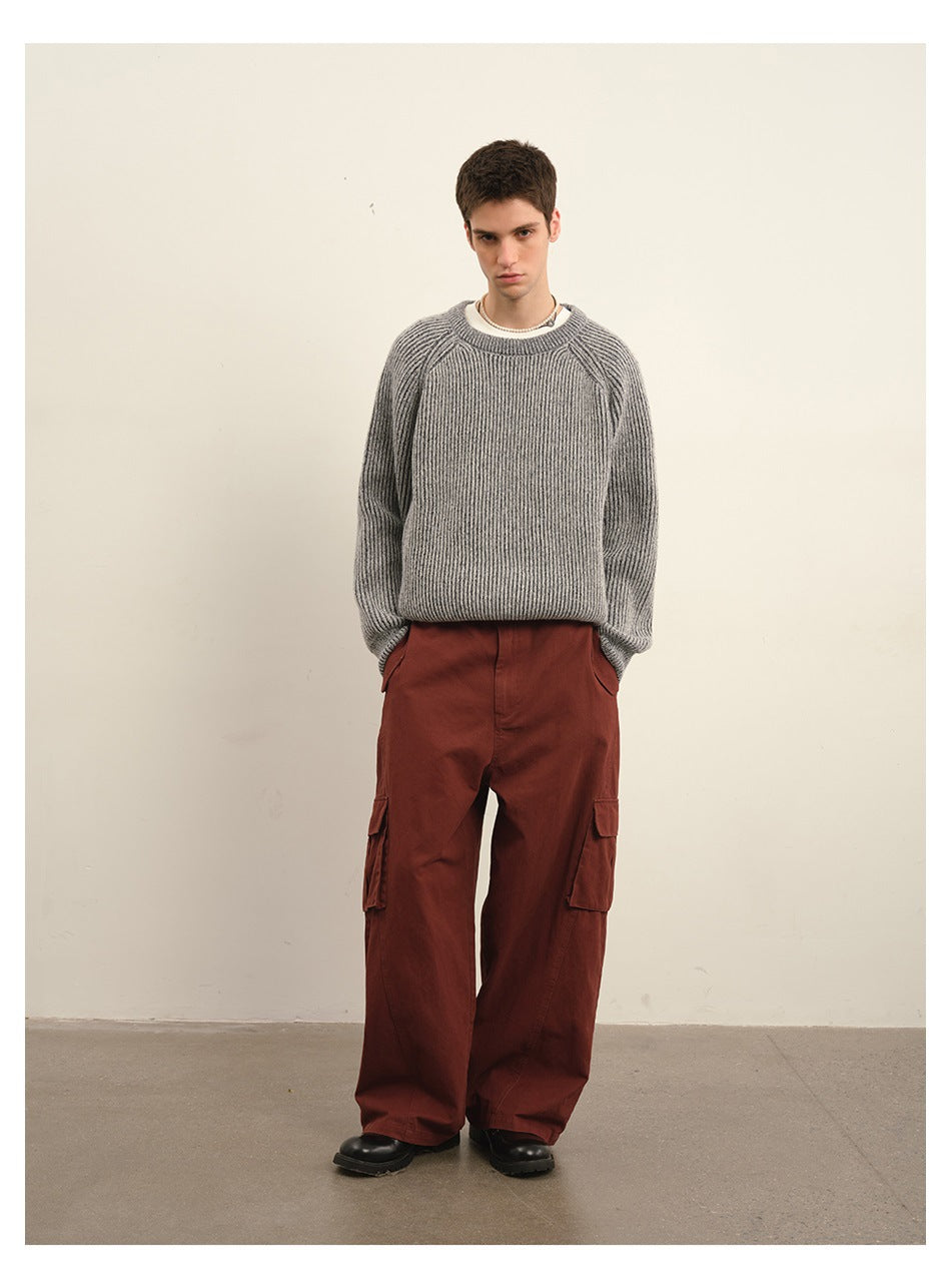 Model wearing rust-red wide-leg cargo trousers with a gray ribbed sweater.