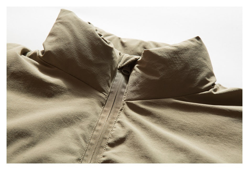 Close-up of a tan jacket's high collar and central zipper.