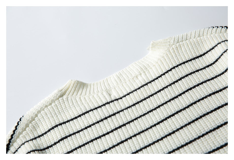 Close-up of the ribbed neckline and black-striped ivory knit fabric.