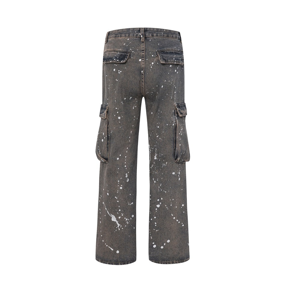 Back view of charcoal-gray splatter-print cargo jeans with rear flap pockets and large side pockets on a white background.