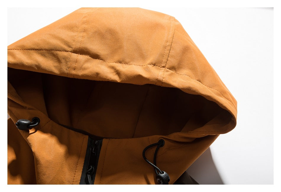 Close-up of the orange jacket's hood, showing its black drawcord and cord locks.