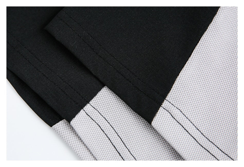 Close-up of black and light gray garment panels with parallel stitching along the seam.