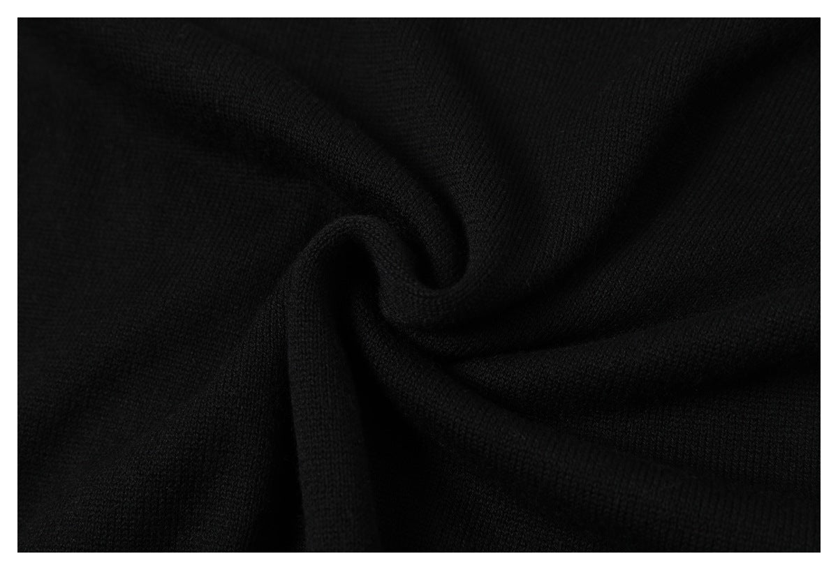 Close-up of black knit fabric gathered into a swirl, showing its fine texture.
