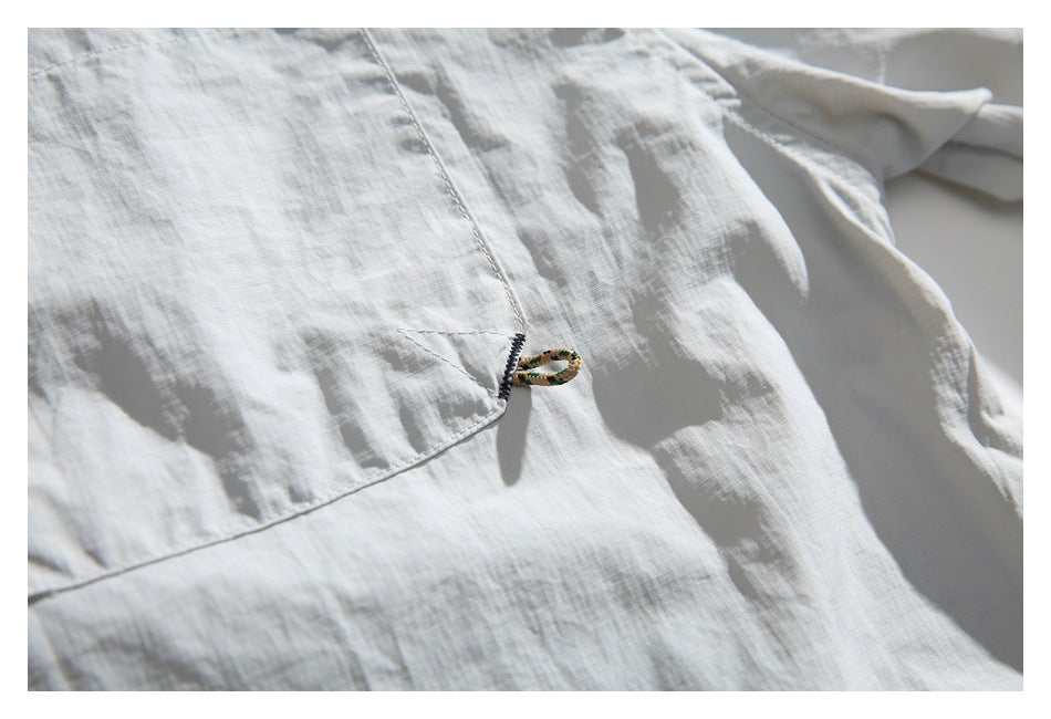 Close-up of a small loop detail beside the chest pocket on the light gray pullover.