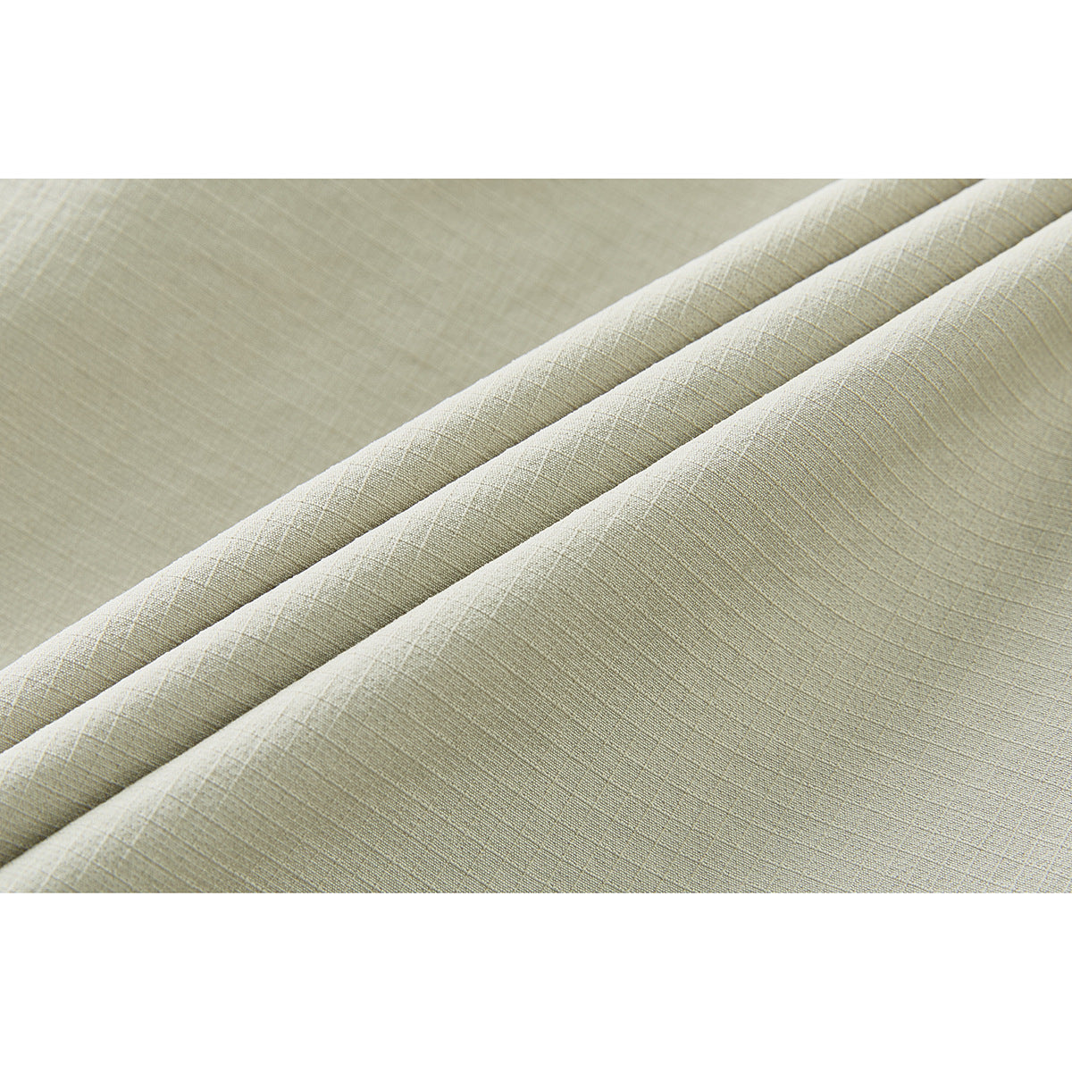 Close-up showing the fine crosshatch texture of pale sage fabric in soft folds.