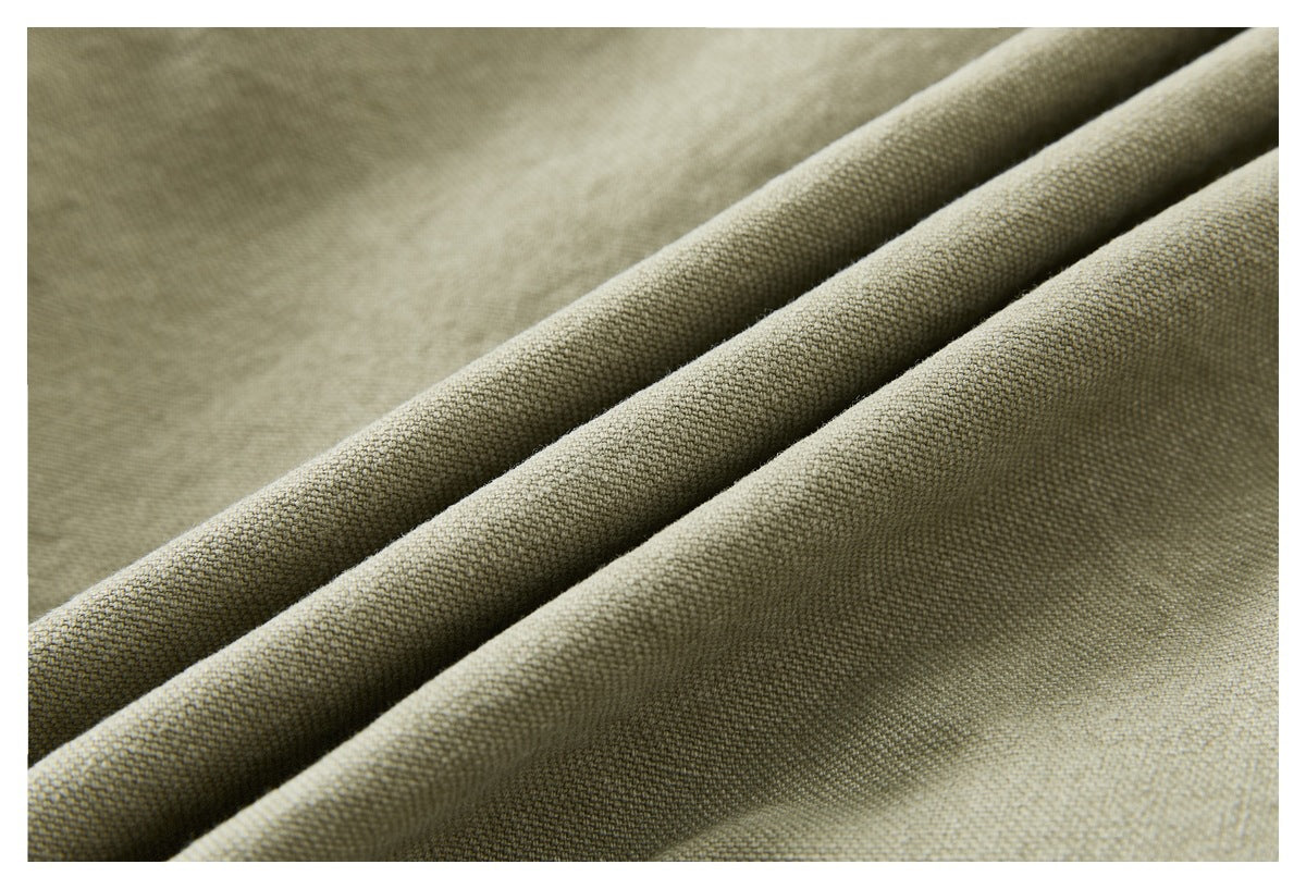 Close-up of beige woven fabric arranged in soft diagonal folds, showing its textured surface.