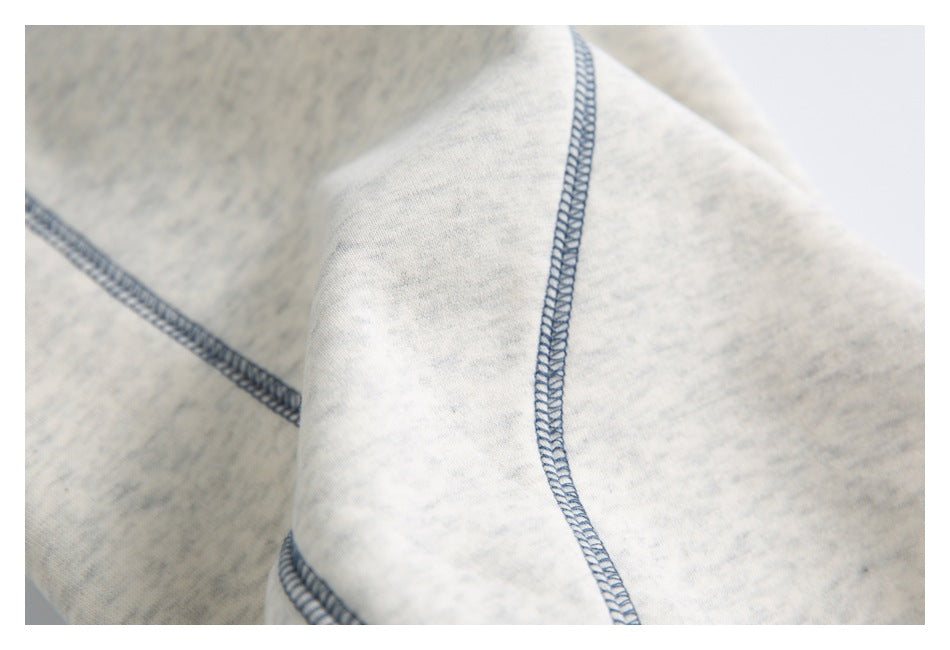 Close-up of blue-gray overlock stitching across the light gray marled jogger fabric.