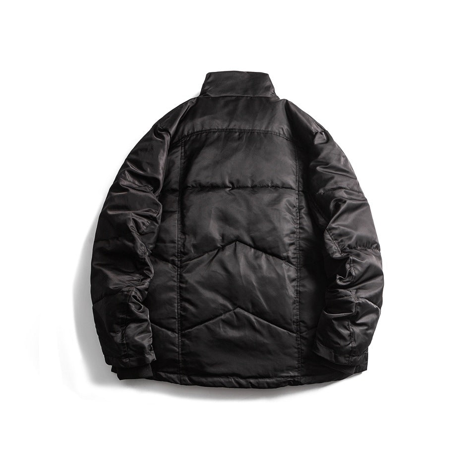 Back view of a black quilted jacket with a raised collar, long sleeves, and geometric stitched panels.