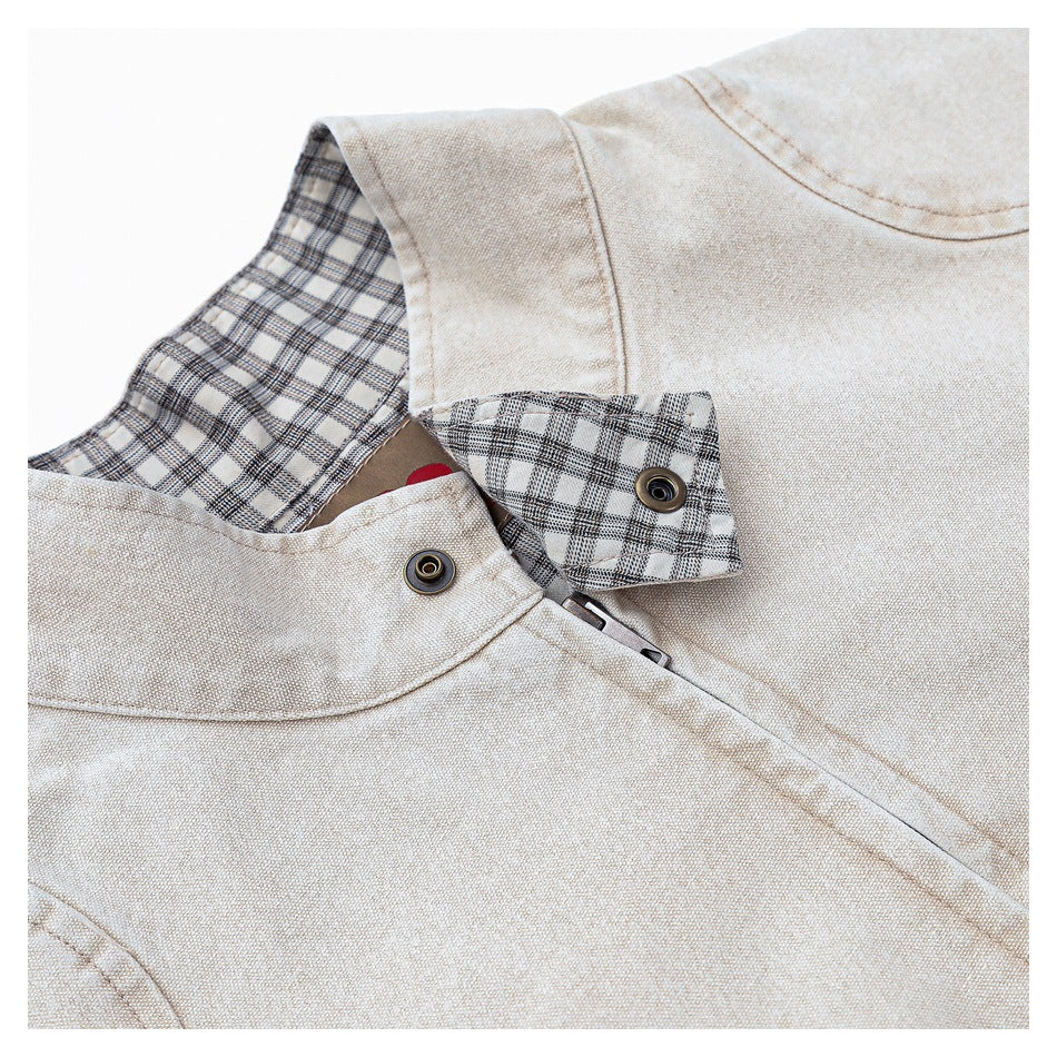 Close-up of the beige jacket's plaid-lined collar, snap fasteners, and textured fabric.