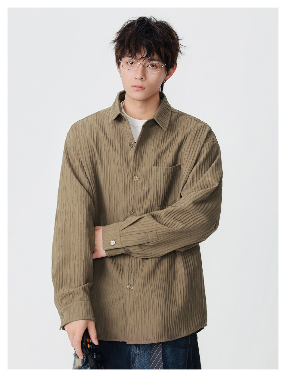 Model wearing an olive-brown button-up overshirt with vertical texture, a chest pocket, and a pointed collar.
