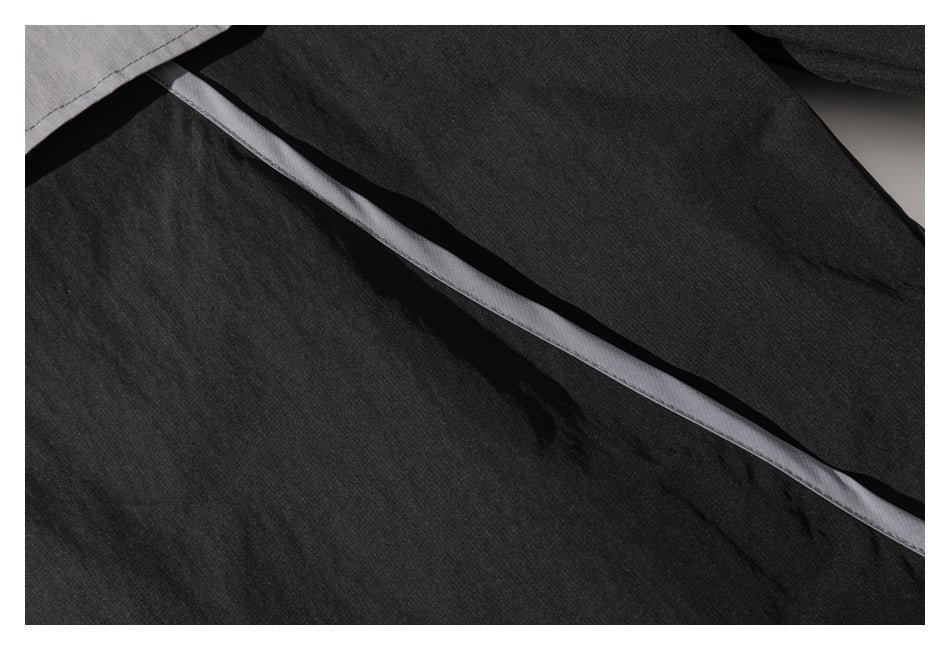 Close-up of black garment panels with a narrow gray strip running diagonally between them.