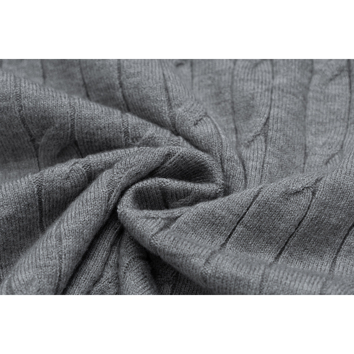 Close-up of the gray top's raised cable-knit pattern and soft folds.
