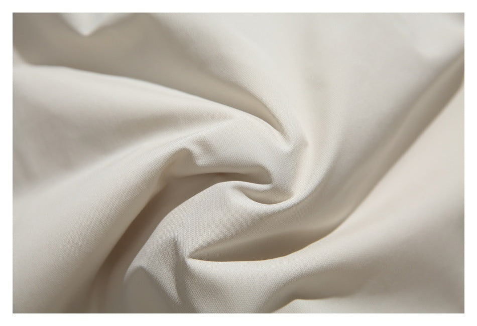 Close-up of softly folded ivory fabric showing its surface and drape.