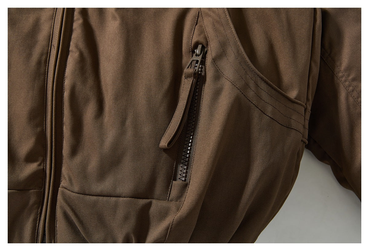 Close-up of a vertical zip pocket and stitched details on the brown jacket.