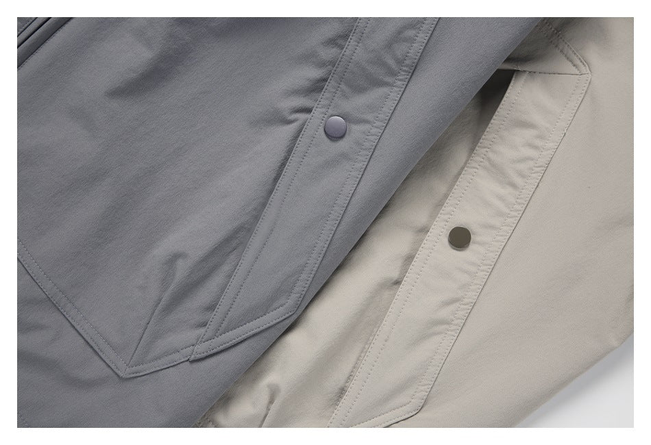 Close-up of overlapping gray and beige garments with stitched snap-button plackets.