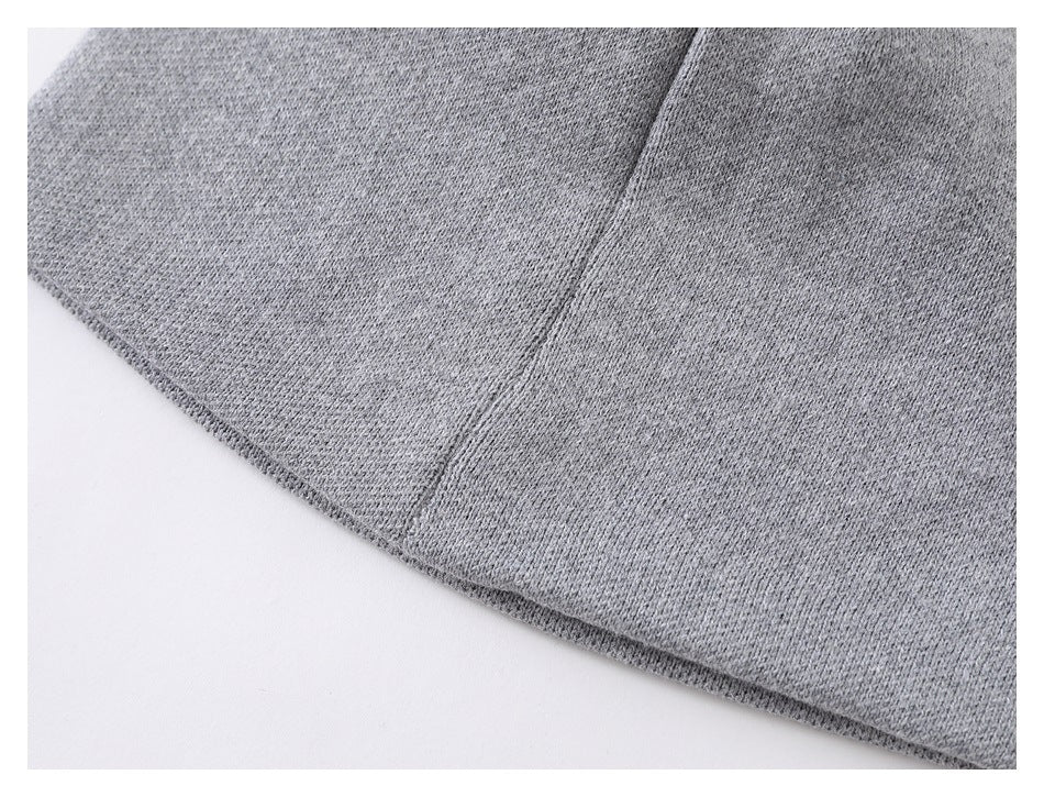 Close-up of a seam and finished edge on the light gray knit beanie.