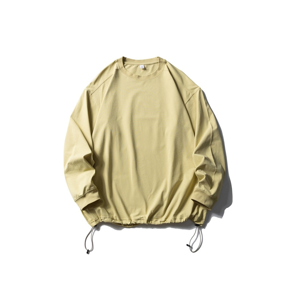 Pale yellow long-sleeve crew-neck top flat lay with drawstring hem and toggle cords