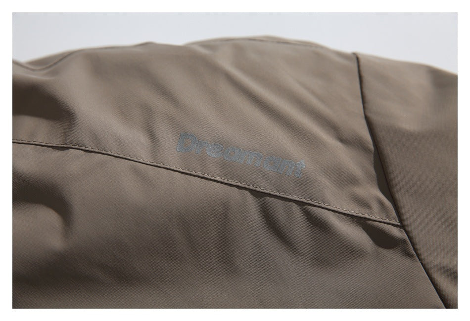 Close-up of an embroidered English wordmark on taupe garment fabric above a stitched seam.