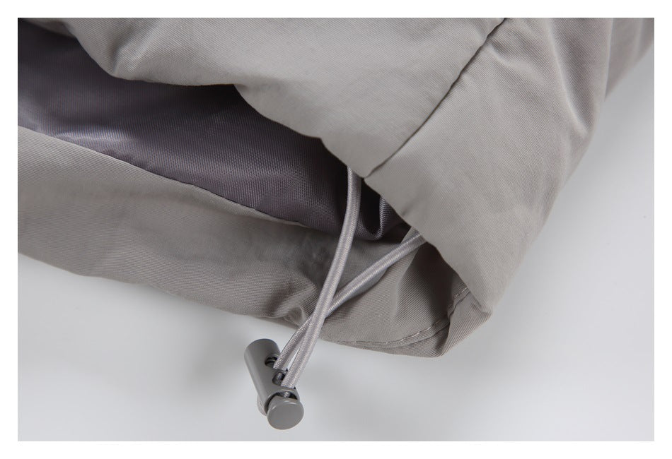 Close-up of a light gray garment hem with an adjustable drawcord and plastic toggle.