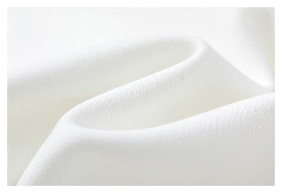 Macro view of the soft-looking white sweatshirt fabric draped in folds.