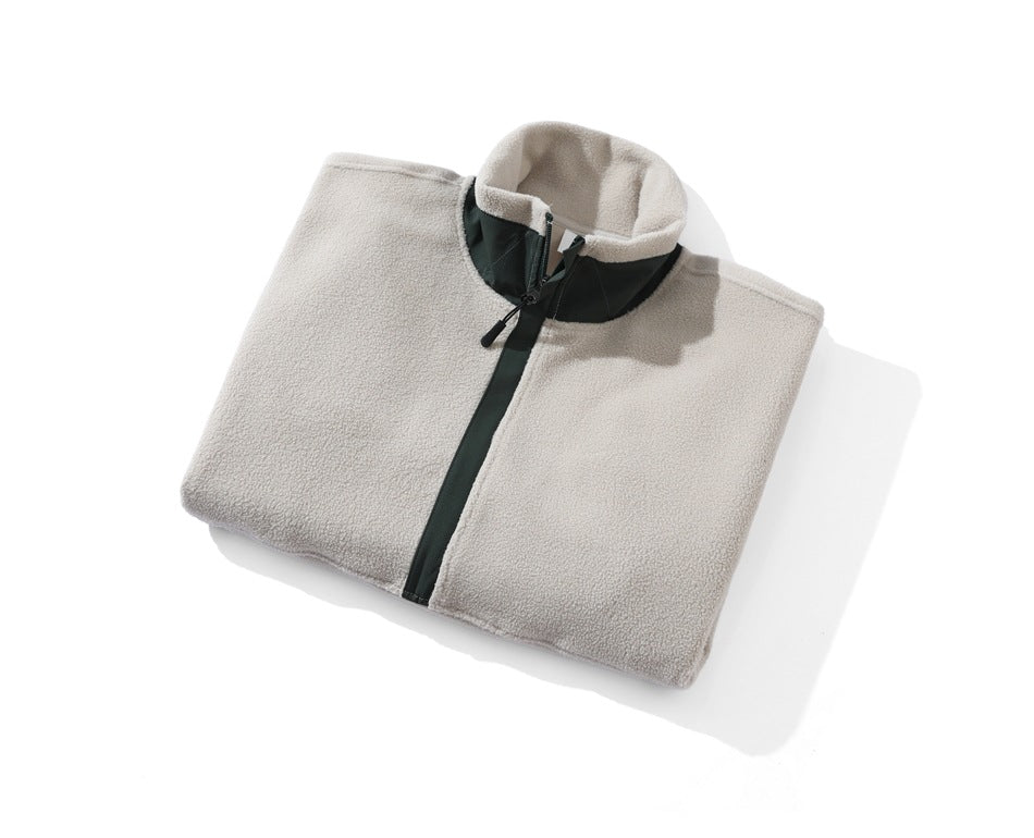 Folded light beige fleece pullover with a dark green quarter-zip placket and stand collar.